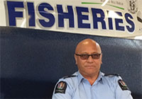 HFO Dennis Karauna standing in front of an MPI boat in a shed