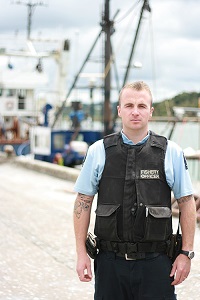 Kyall in uniform, standing on a wharf.