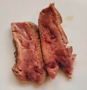 An undercooked chicken liver cut in half to show it is red inside.