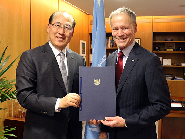 New Zealand High Commissioner to the United Kingdom, Sir Lockwood Smith, presents the instrument of accession to IMO Secretary-General Kitack Lim.